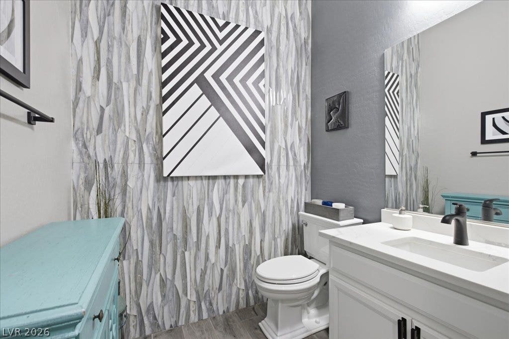 181 Elder View Drive, Las Vegas, NV 89138 A refined bathroom featuring a contemporary sink, modern toilet, and elegantly textured tile wall.