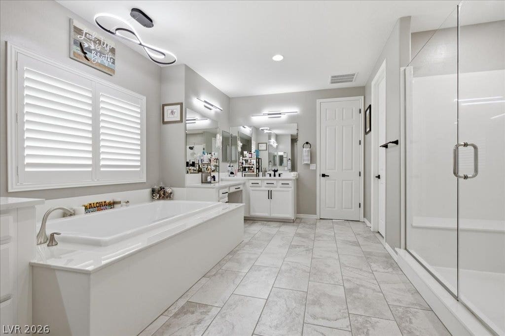 181 Elder View Drive, Las Vegas, NV 89138 Relax in this luxurious primary bathroom, featuring a deep soaking tub and a spacious walk-in shower.