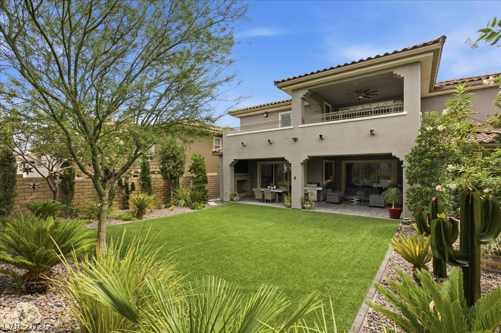 181 Elder View Drive, Las Vegas, NV 89138 An inviting backyard oasis offers ample green space, a sheltered patio, and a second-story balcony for outdoor enjoyment.