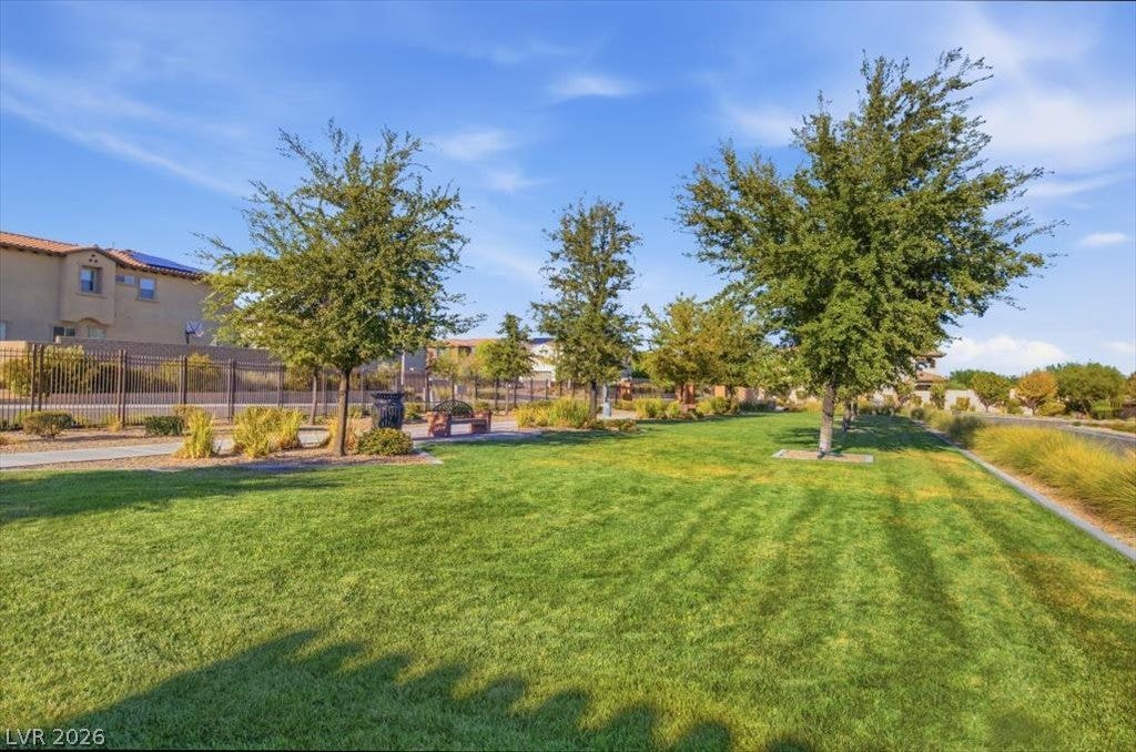 181 Elder View Drive, Las Vegas, NV 89138 Mature trees shade a manicured grassy common area bordered by community sidewalks and fencing.