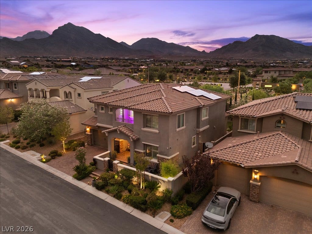 181 Elder View Drive, Las Vegas, NV 89138 Dramatic mountain peaks frame this multi-level residence with tile roofing and modern desert landscaping.