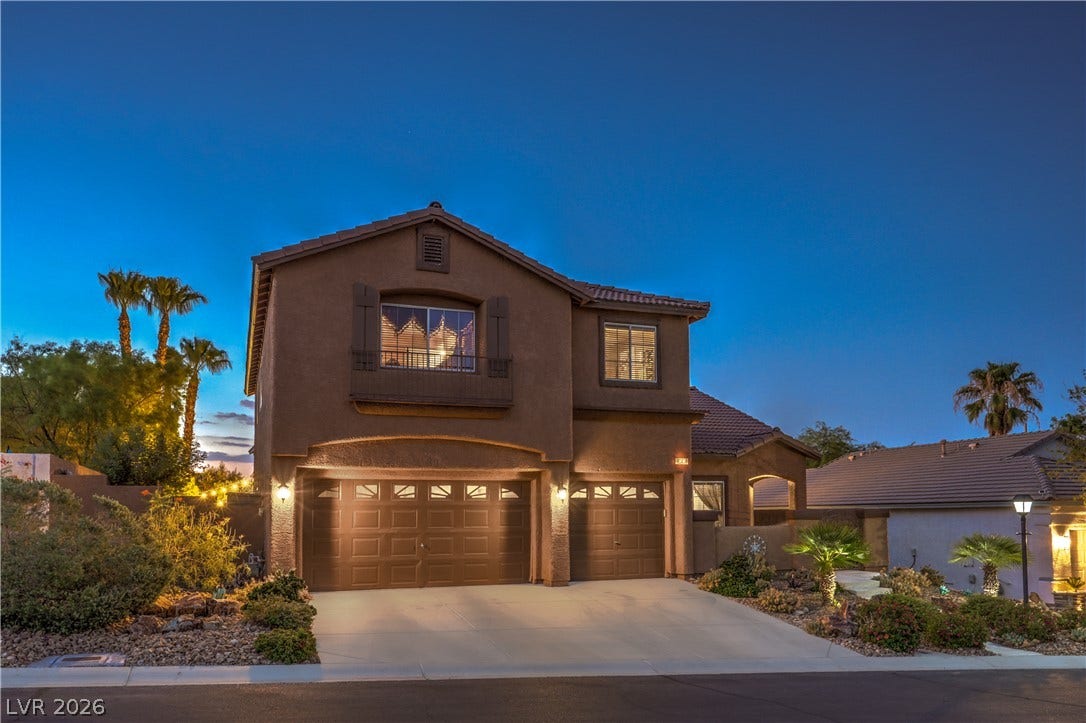 10474 Rustyville Court, Las Vegas, NV 89129 Illuminated by dusk, this dwelling showcases a three-car garage, mature landscaping, and inviting architectural elements.