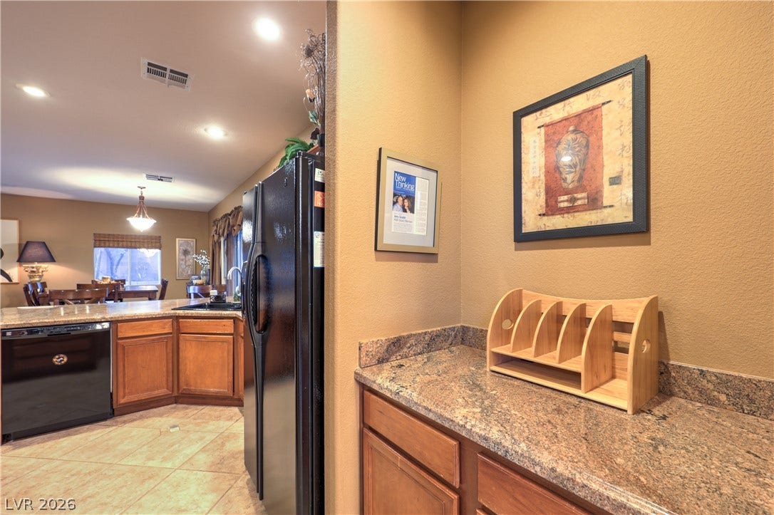 10474 Rustyville Court, Las Vegas, NV 89129 Extra counter space by the pantry granite countertops and rich wood cabinetry define this well-appointed area.