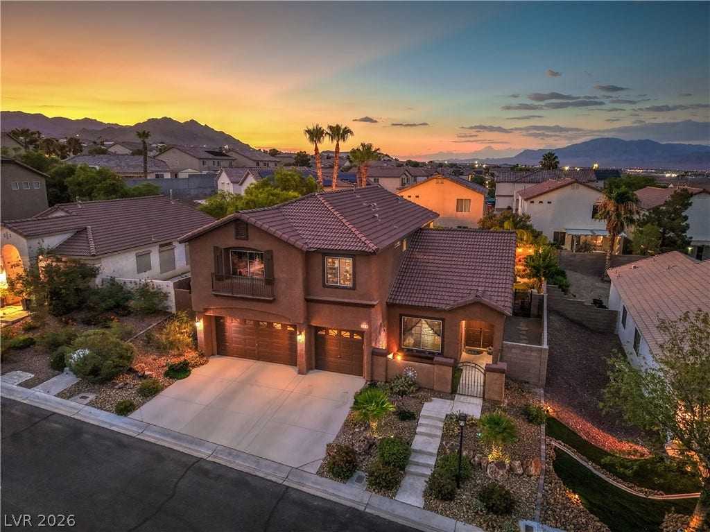 10474 Rustyville Court, Las Vegas, NV 89129 An inviting exterior with a manicured front yard, a 3 car garage, and captivating mountain views at sunset.