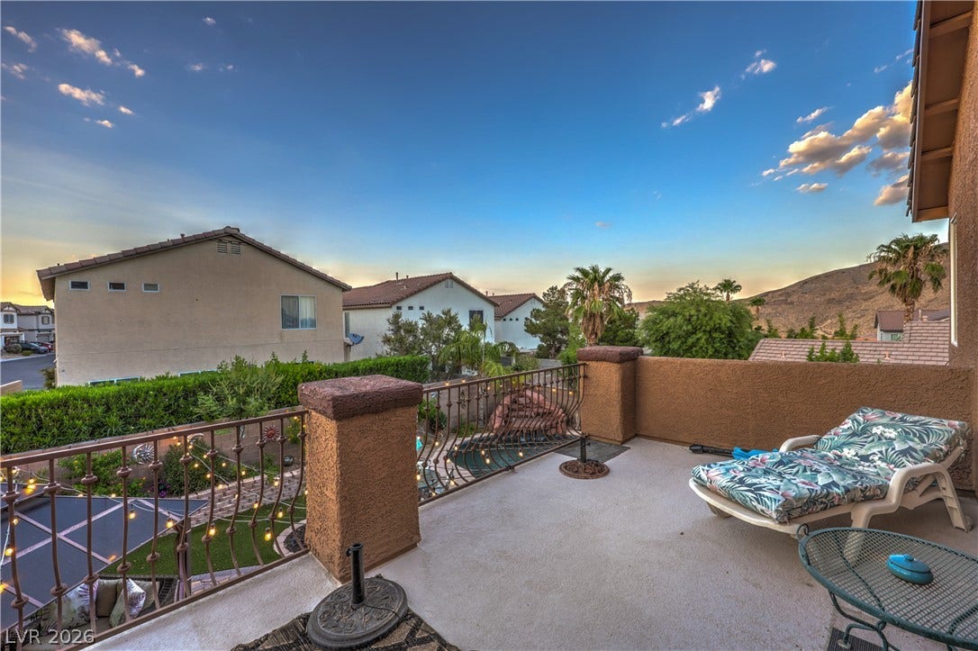 10474 Rustyville Court, Las Vegas, NV 89129 An inviting balcony overlooks a manicured yard and distant mountains, ideal for serene evenings.