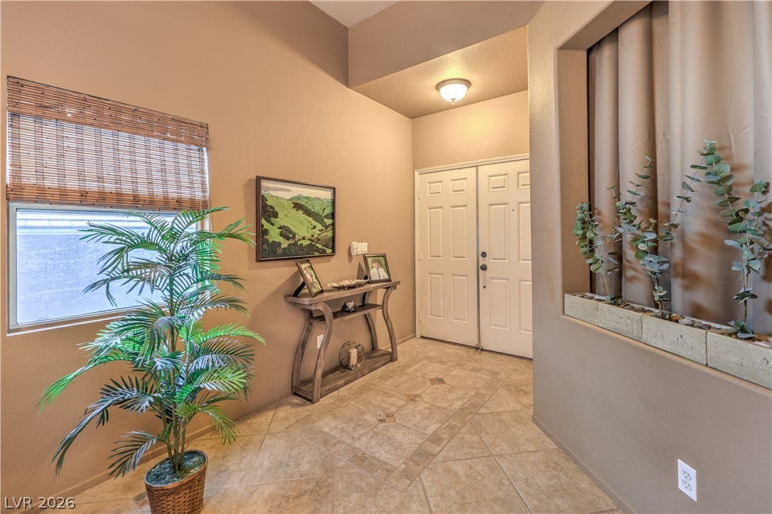 10474 Rustyville Court, Las Vegas, NV 89129 Step into a welcoming entry featuring elegant tiled flooring and a sun-filled window.