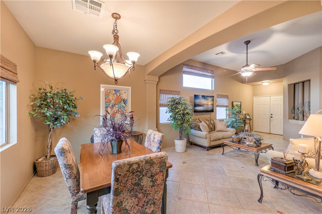 10474 Rustyville Court, Las Vegas, NV 89129 An inviting open-concept living and dining area features neutral tones and tiled flooring throughout.