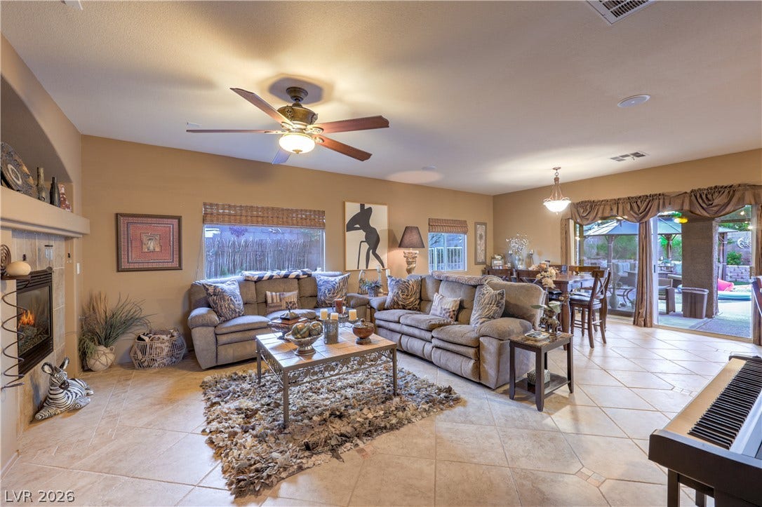 10474 Rustyville Court, Las Vegas, NV 89129 A welcoming living space with tile flooring transitions seamlessly to a dining area and outdoor patio.