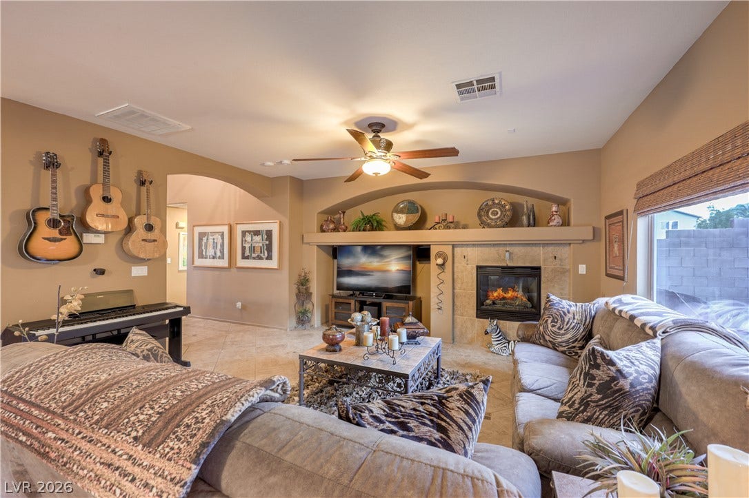 10474 Rustyville Court, Las Vegas, NV 89129 A welcoming living area offers a cozy fireplace and tile flooring, ideal for gatherings.