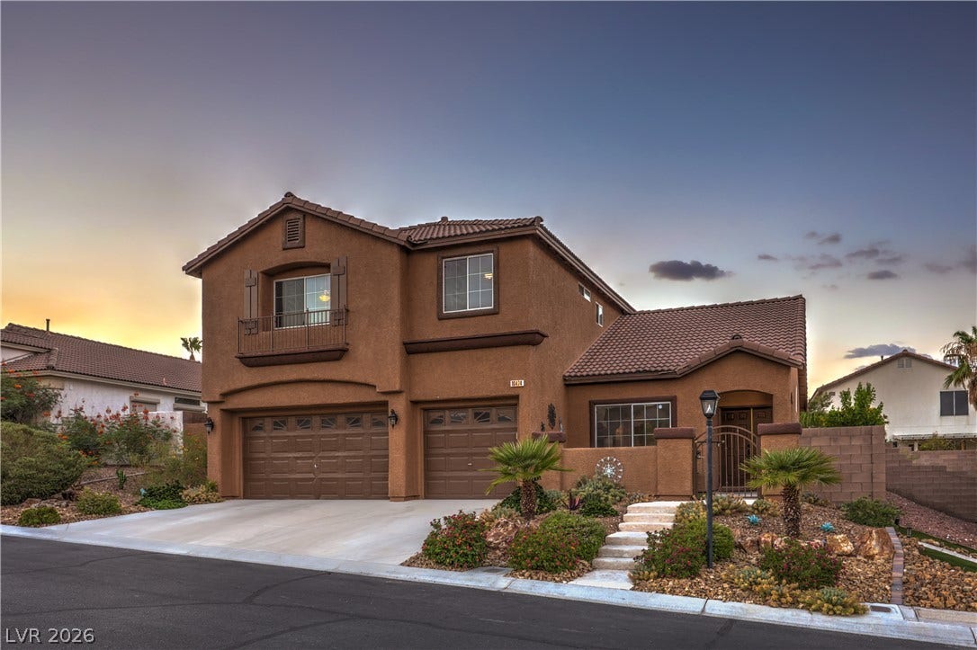 10474 Rustyville Court, Las Vegas, NV 89129 A terracotta-hued residence welcomes with a tiled roof, inviting entryway, and a verdant, low-maintenance desert landscape.