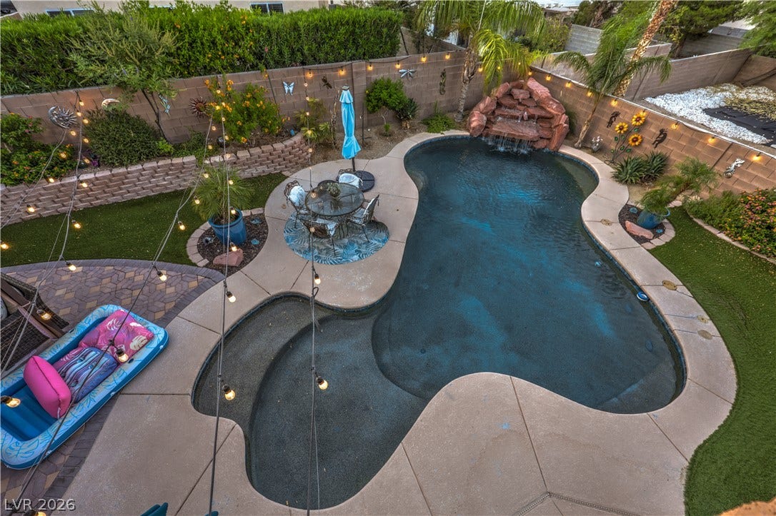 10474 Rustyville Court, Las Vegas, NV 89129 An inviting backyard oasis offers a free-form pool with a rock waterfall and surrounding patio for leisure. Separate lounge levels at different depts.