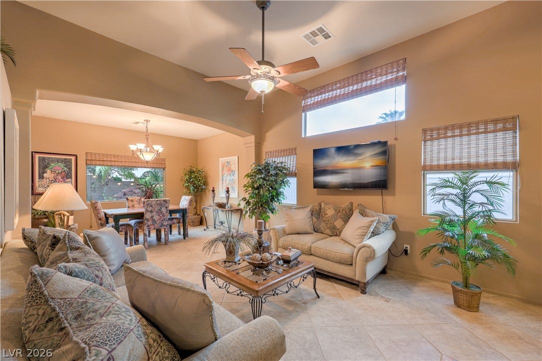 10474 Rustyville Court, Las Vegas, NV 89129 A comfortable great room connects to a bright dining area, featuring high ceilings and elegant tile flooring throughout.