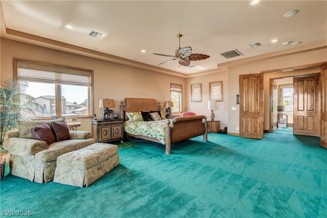 Thick wood trim frames the windows in this generously proportioned primary bedroom suite.