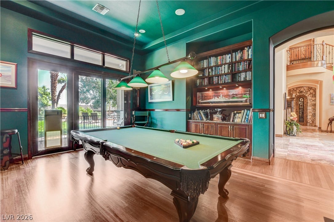 Gleaming hardwood floors and a built-in bookcase highlight this versatile recreation space.