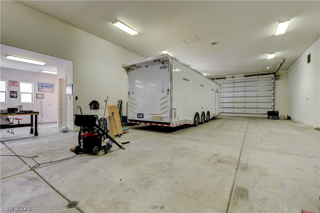 Massive garage space offers concrete flooring and high ceilings with abundant overhead lighting.