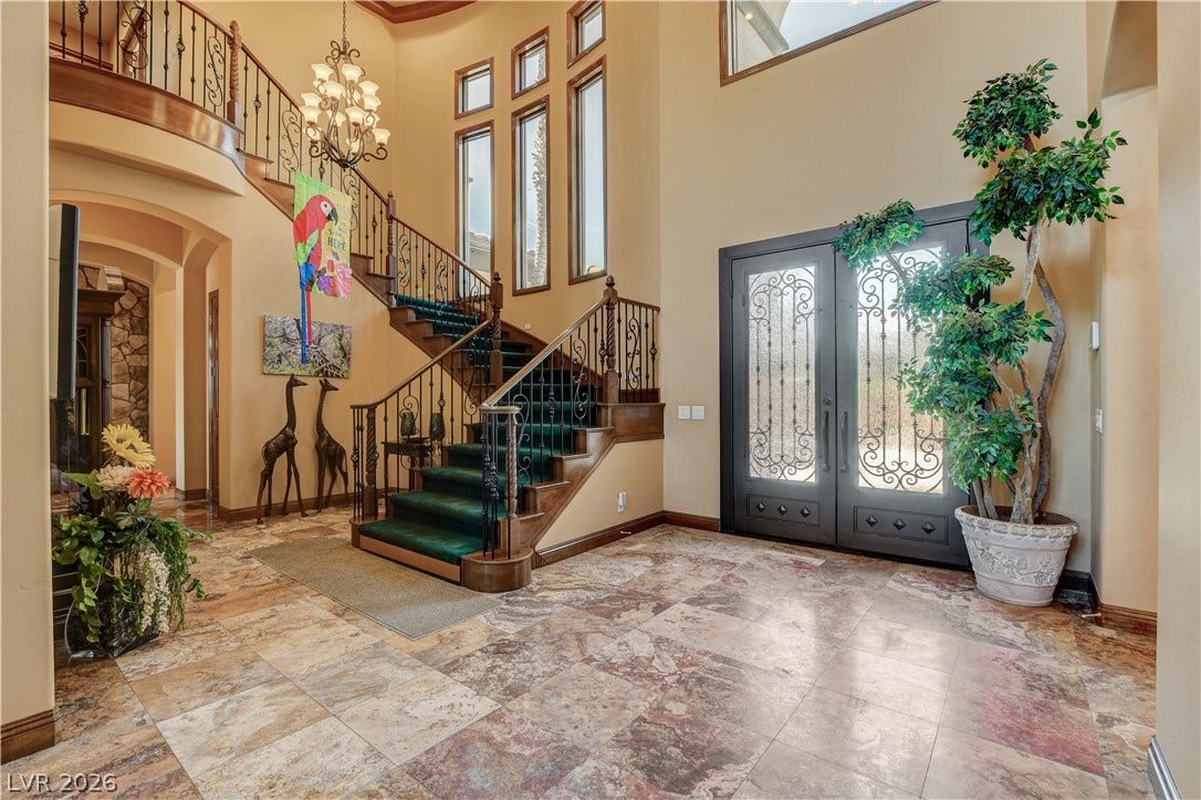 Double entry doors open to a soaring foyer anchored by an elegant winding staircase.