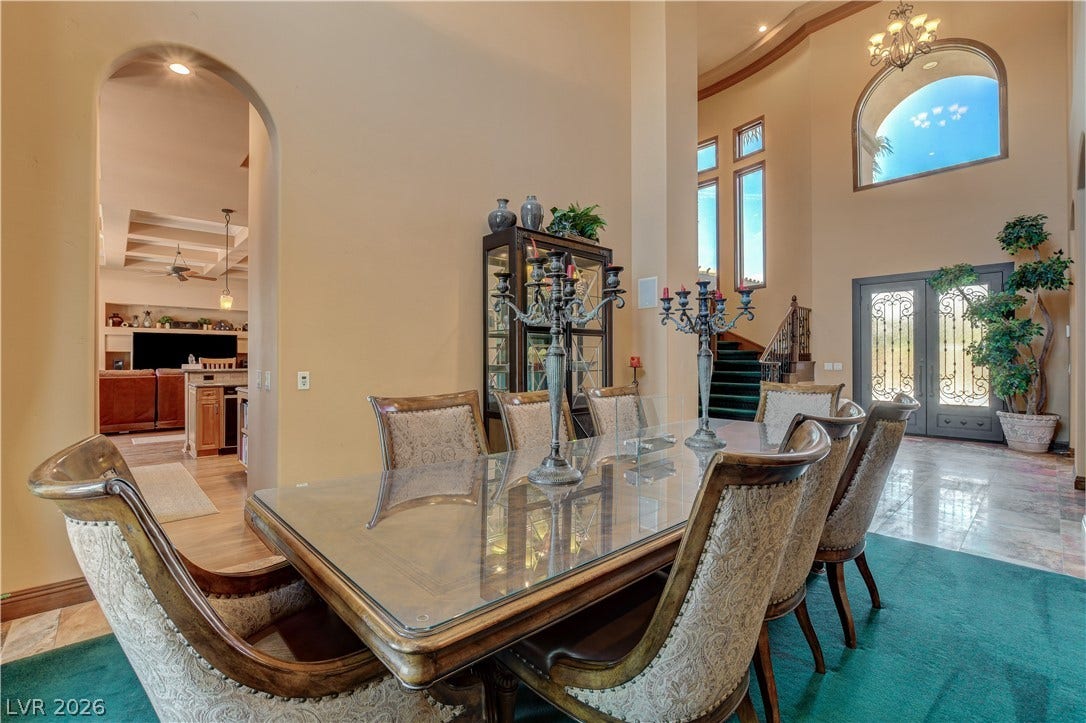 Grand two-story ceilings and arched details define this elegant formal dining space.