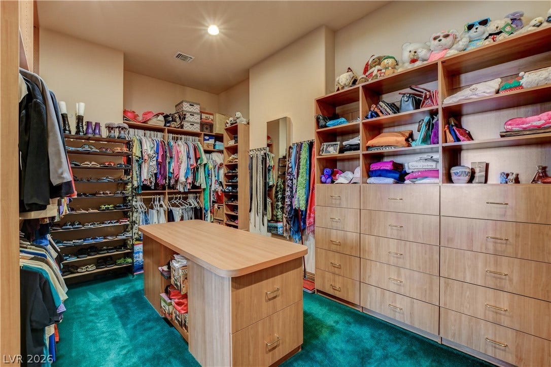 Ample custom shelving and integrated storage drawers define this organized closet space.