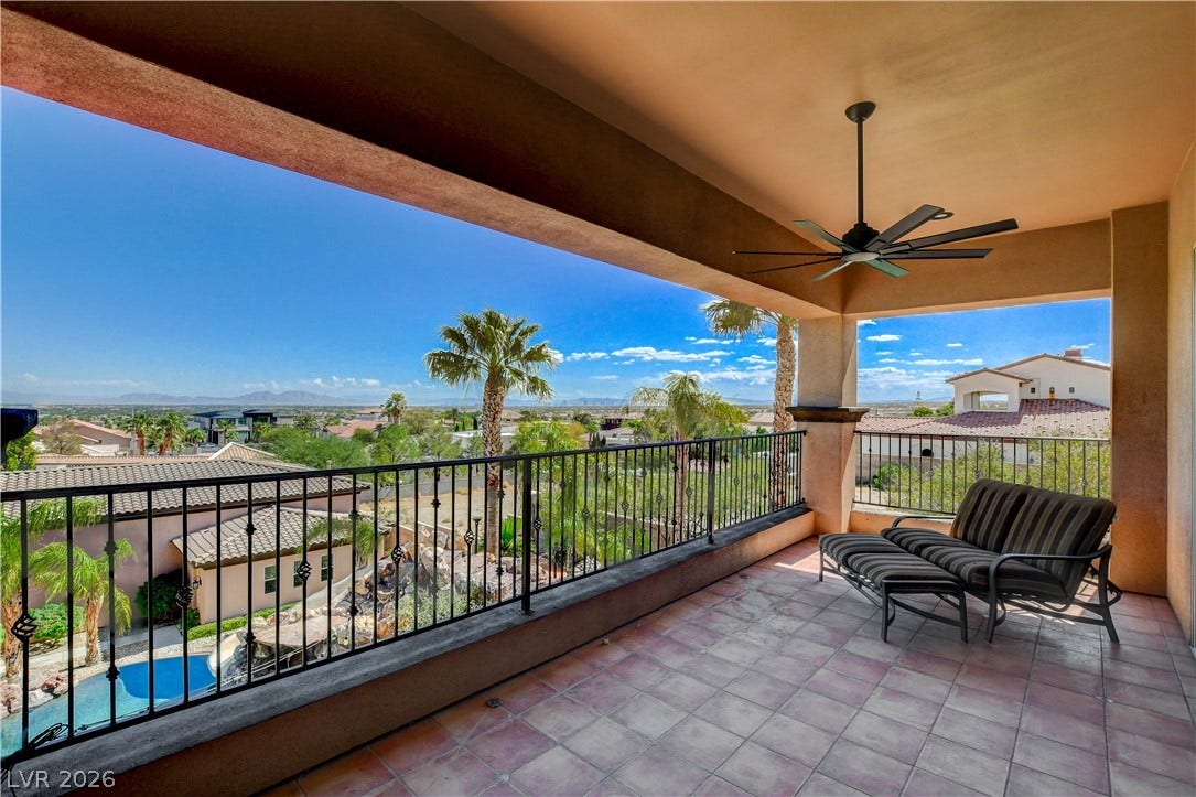 A spacious covered balcony provides sweeping views of the surrounding neighborhood and desert mountains.