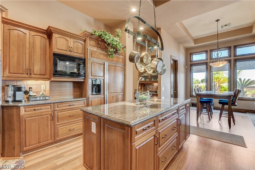 Rich wood cabinetry and polished granite counters anchor this well-appointed gourmet space.
