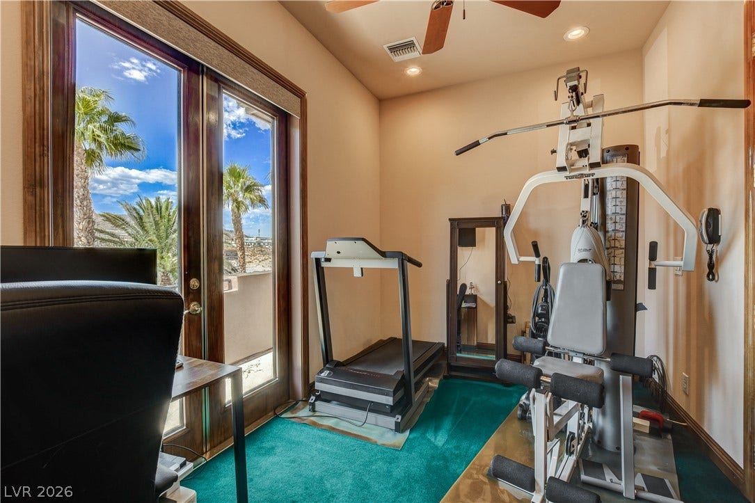 Double glass doors open to outdoor views from this versatile home gym space.