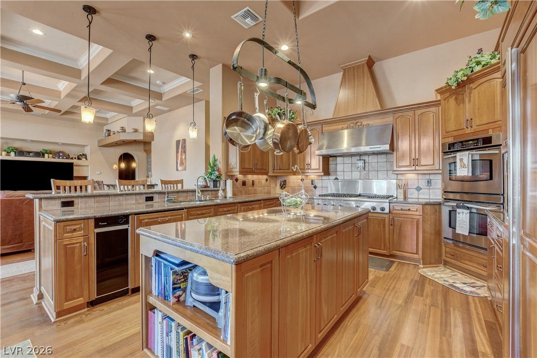 Rich wood cabinetry paired with stone countertops defines this central cooking and dining space.