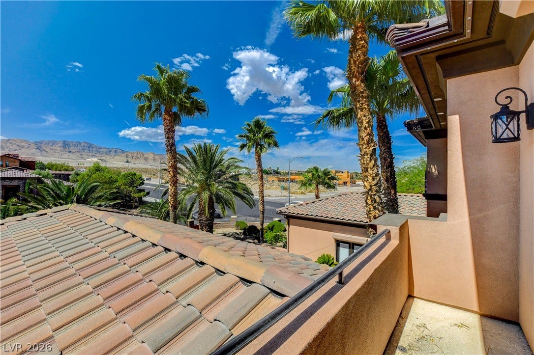 Palm trees framing scenic mountain views from an elevated vantage point.