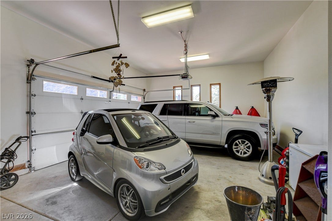 A spacious garage features a durable concrete floor and multiple windows providing natural light.