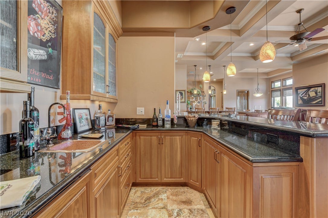 Gleaming stone countertops and custom cabinetry define this thoughtfully crafted entertaining space.