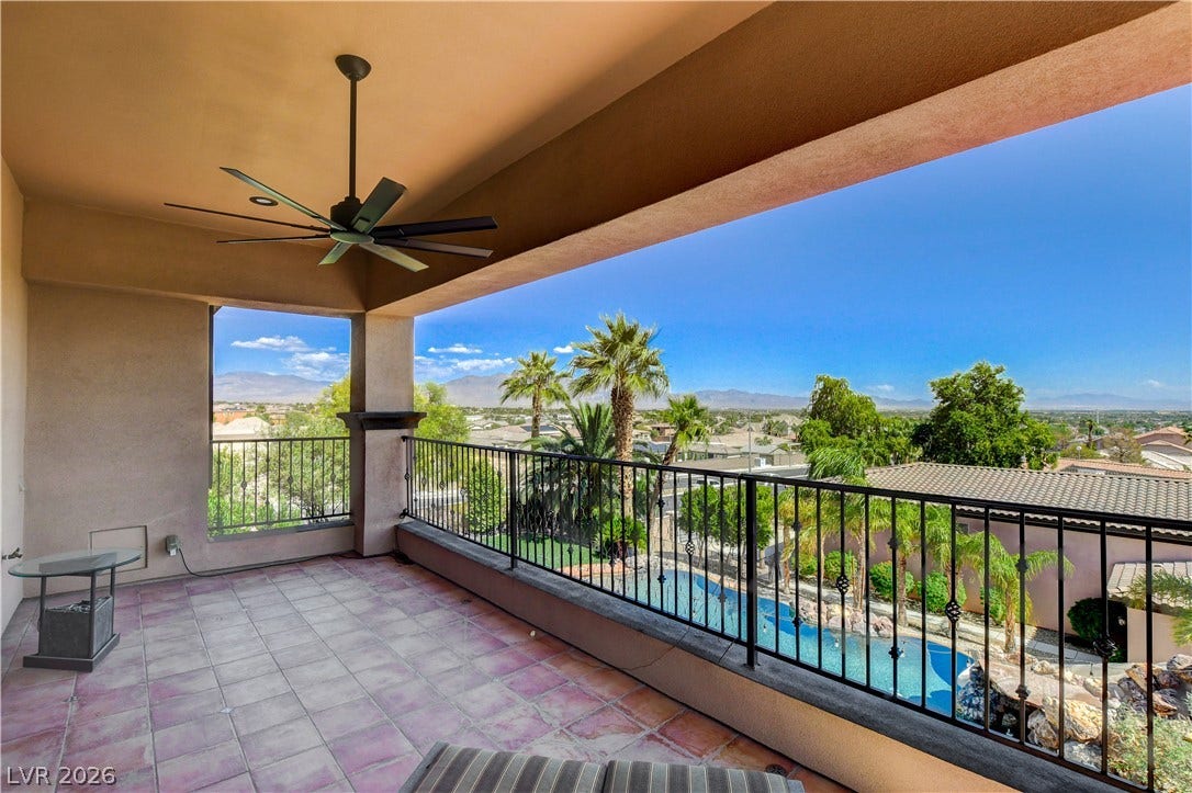 An elevated covered balcony overlooks the sparkling swimming pool and distant mountain ranges.