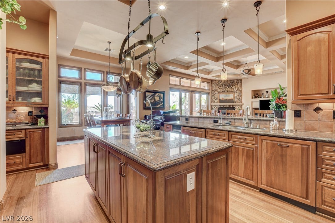Gleaming wood floors pair with customized cabinetry and a substantial stone-topped island.