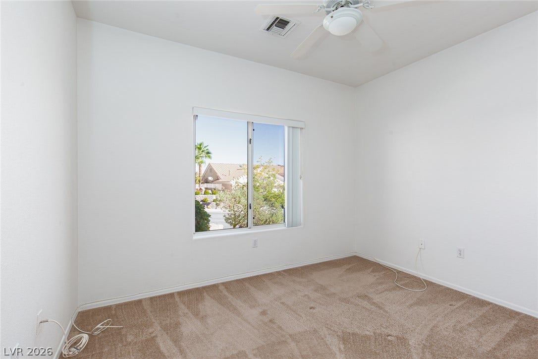 10725 Windledge Avenue, Las Vegas, NV 89134 A spacious room features plush neutral carpeting and a large window looking outdoors.
