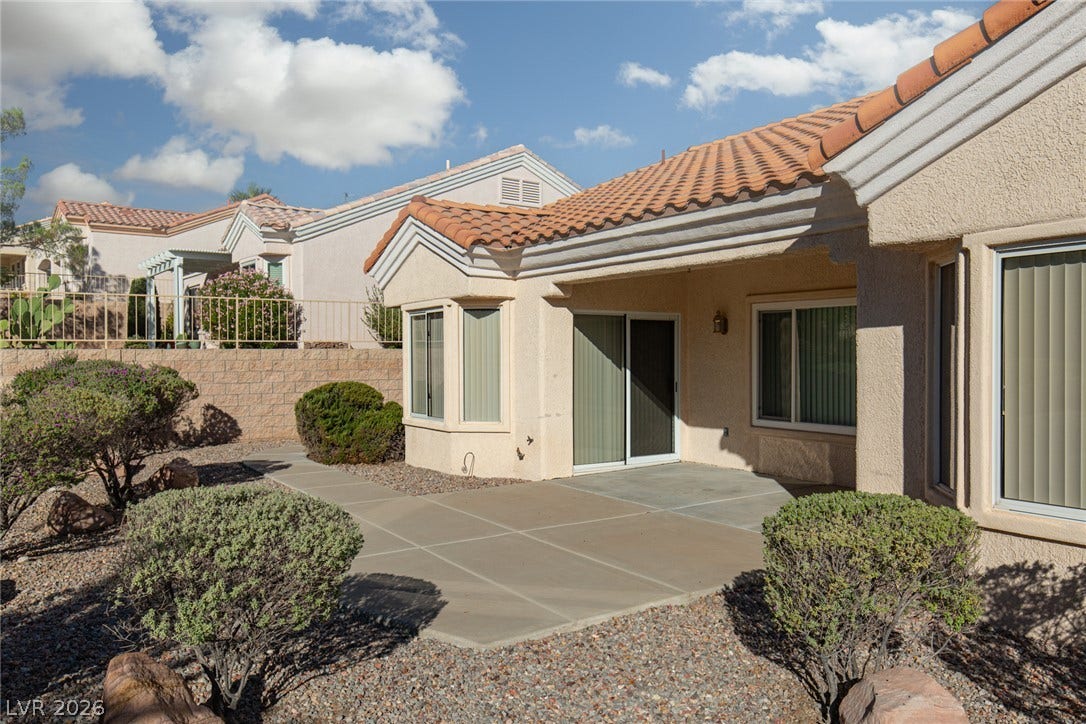 10725 Windledge Avenue, Las Vegas, NV 89134 Spanish tile roofing and low-maintenance desert landscaping frame a private back patio space.