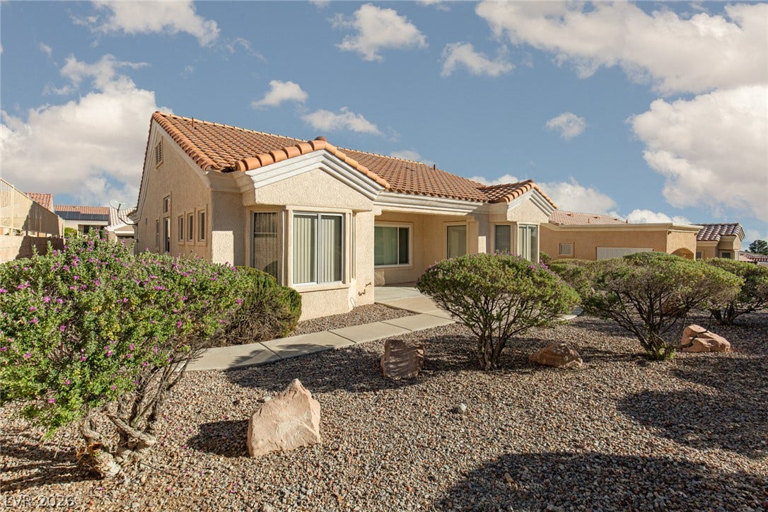 10725 Windledge Avenue, Las Vegas, NV 89134 Spanish tile roofing and low-maintenance desert landscaping define the exterior of this classic stucco home.