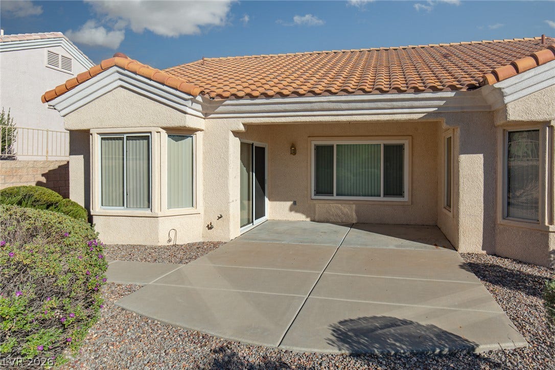 10725 Windledge Avenue, Las Vegas, NV 89134 Concrete patio spaces sit beneath a tile roof on the rear exterior of this home.