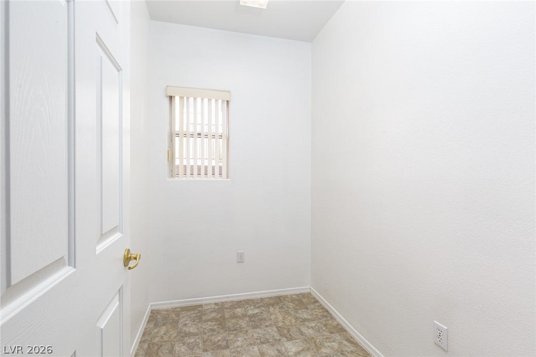 10725 Windledge Avenue, Las Vegas, NV 89134 An intimate utility space with durable stone-patterned tile flooring and a small vertical window.