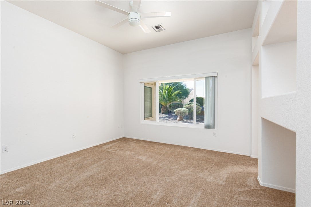 10725 Windledge Avenue, Las Vegas, NV 89134 A spacious room features plush carpeting and a large window framing desert landscaping.