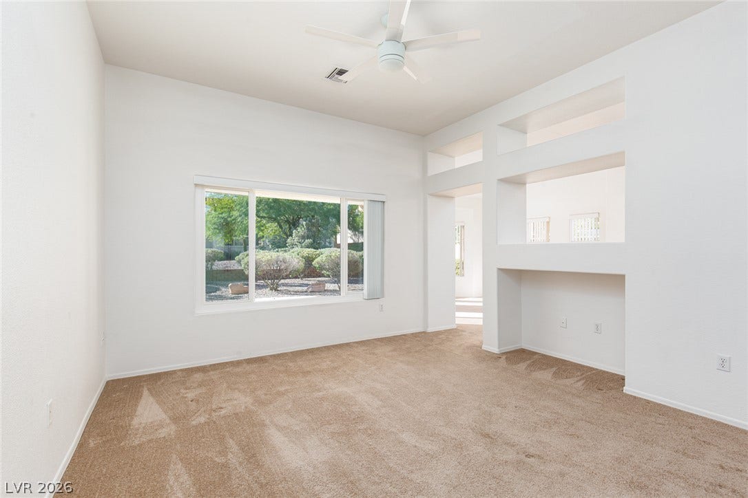 10725 Windledge Avenue, Las Vegas, NV 89134 A spacious interior room features carpeted flooring and custom built-in wall cutouts.