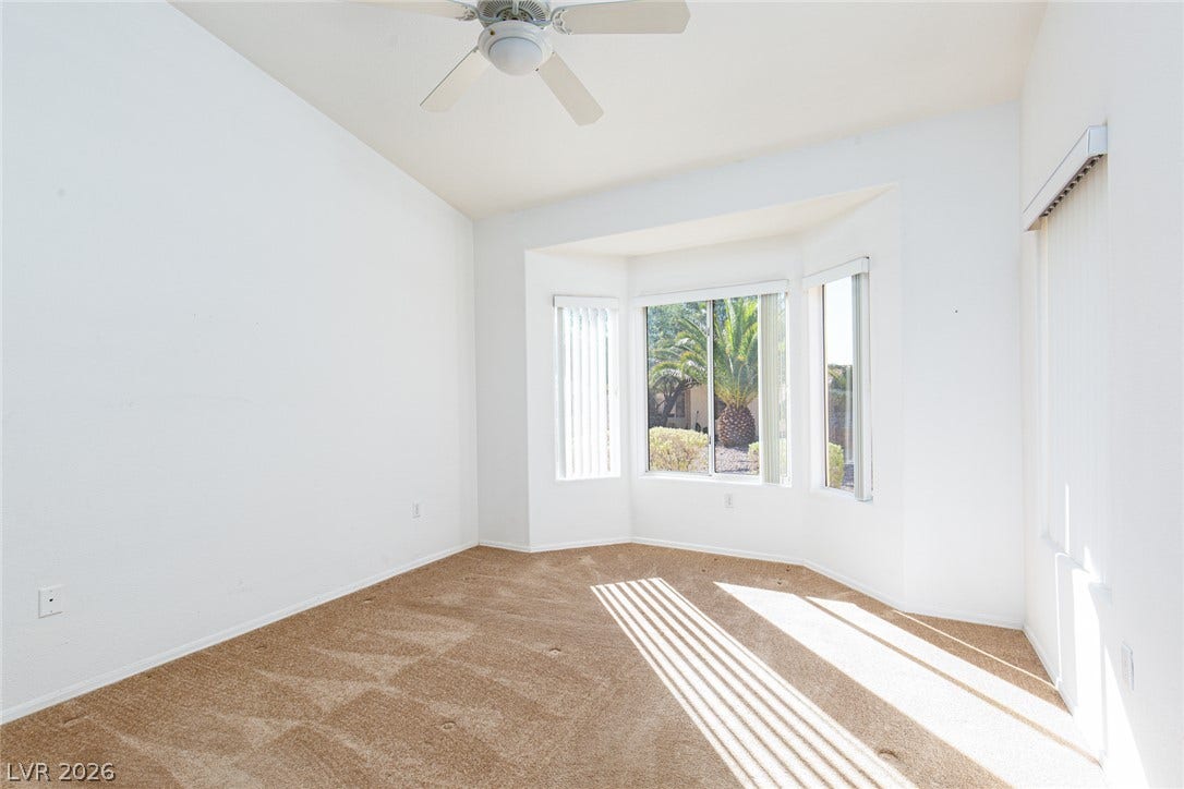 10725 Windledge Avenue, Las Vegas, NV 89134 Sunlight streams across plush carpeting through a classic bay window framing garden views.