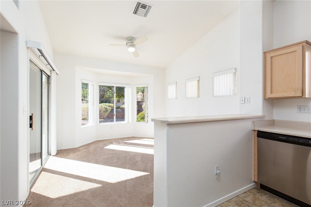 10725 Windledge Avenue, Las Vegas, NV 89134 Sunlight streams across a carpeted living space framed by a distinct bay window detail.