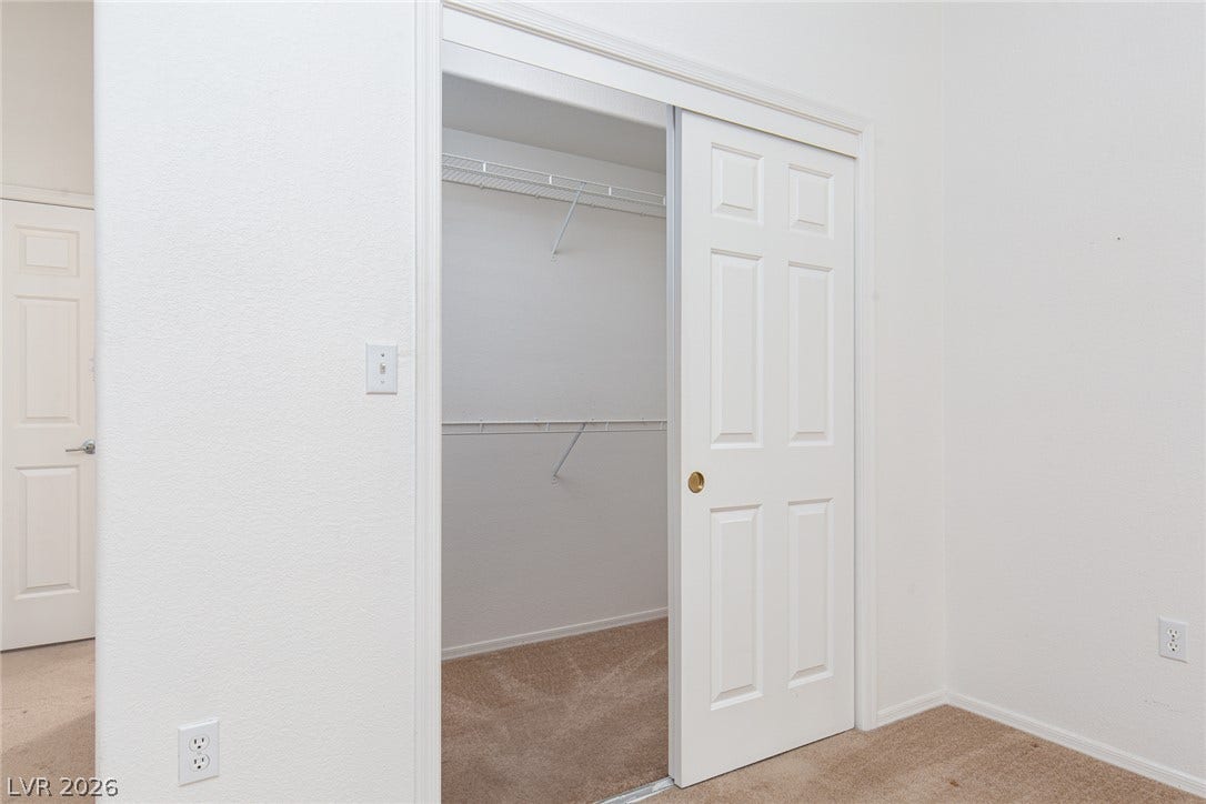 10725 Windledge Avenue, Las Vegas, NV 89134 Sliding doors open to reveal structured wire shelving inside a carpeted storage space.