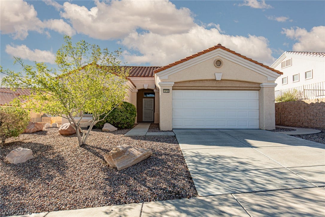 10725 Windledge Avenue, Las Vegas, NV 89134 A classic stucco exterior features a tiled roof and a tidy concrete driveway.