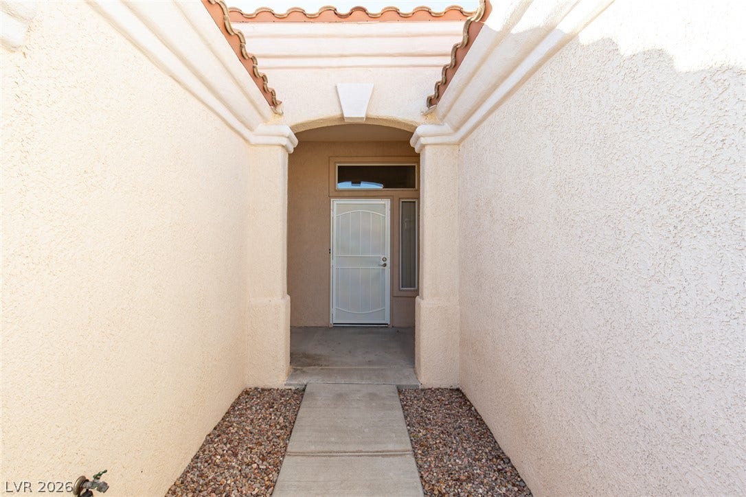 10725 Windledge Avenue, Las Vegas, NV 89134 An arched stucco entryway with a concrete path leads directly to the front door.