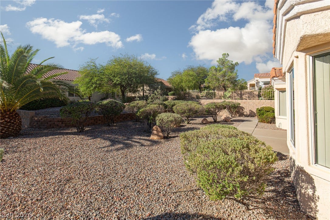 10725 Windledge Avenue, Las Vegas, NV 89134 Desert-inspired landscaping and neat gravel paths frame this classic stucco exterior under open skies.