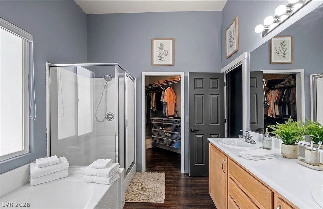 6163 Bayard Street, Las Vegas, NV 89148 A glass-enclosed shower and adjacent soaking tub define this bathroom with an attached walk-in closet.
