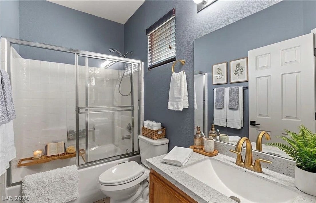6163 Bayard Street, Las Vegas, NV 89148 A classic tub shower with glass enclosure sits adjacent to a stone vanity.