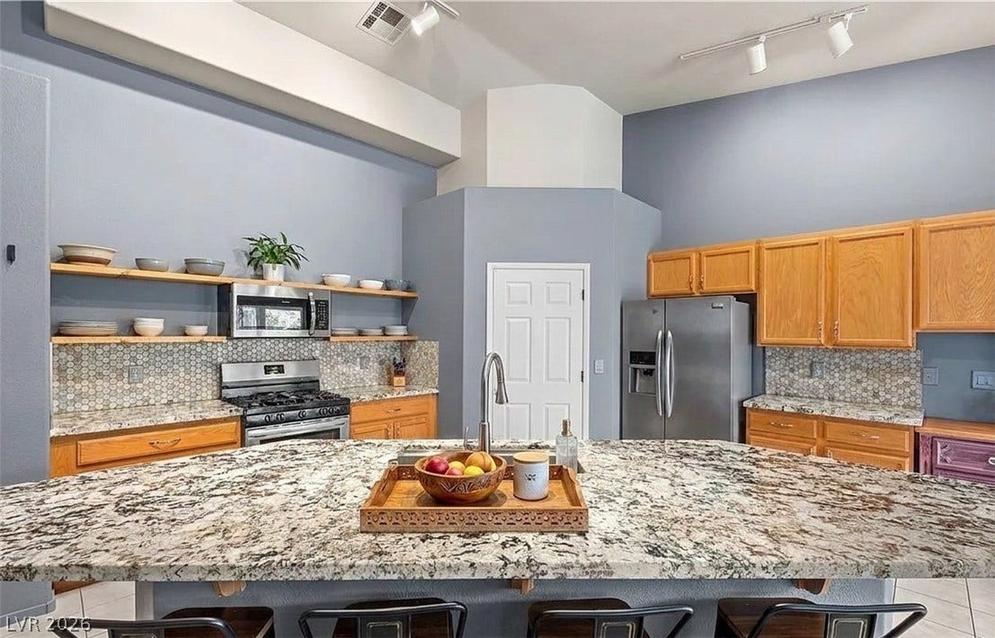 6163 Bayard Street, Las Vegas, NV 89148 Gleaming granite countertops pair with natural wood cabinetry in this vaulted culinary space.