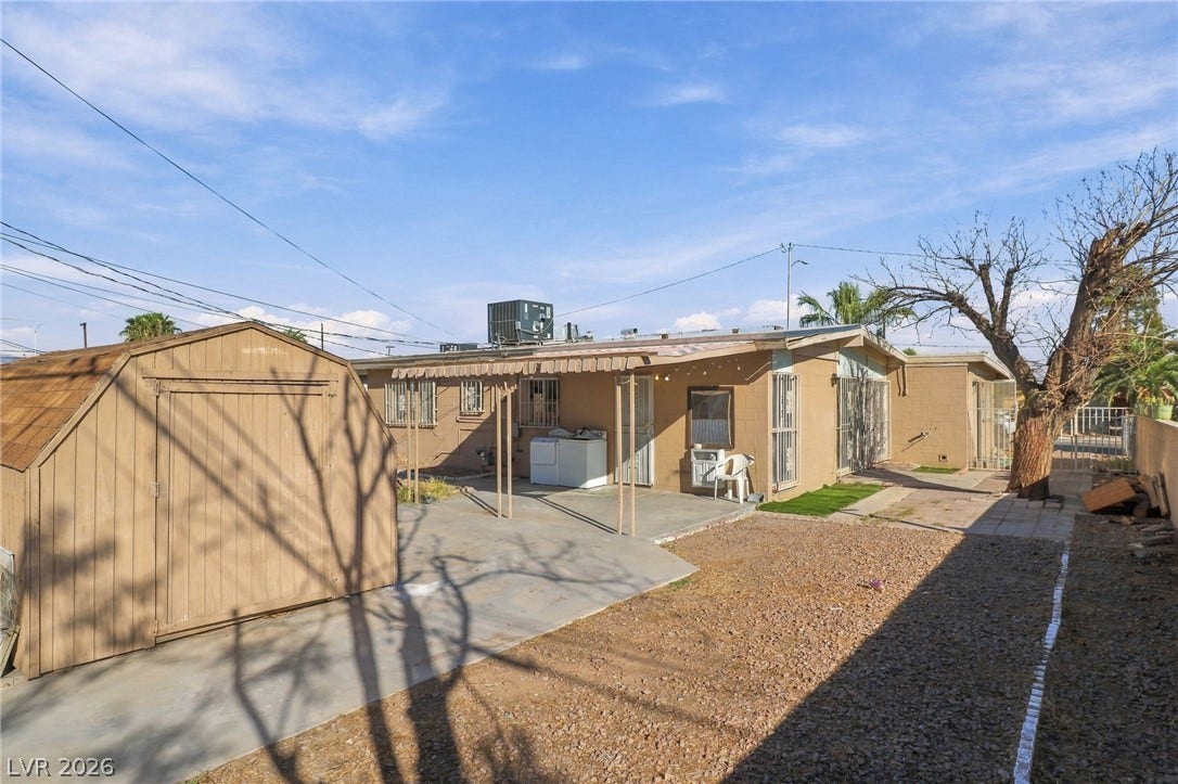 2521 Perliter Avenue, North Las Vegas, NV 89030 A spacious backyard area includes a paved patio and a freestanding wooden storage shed.