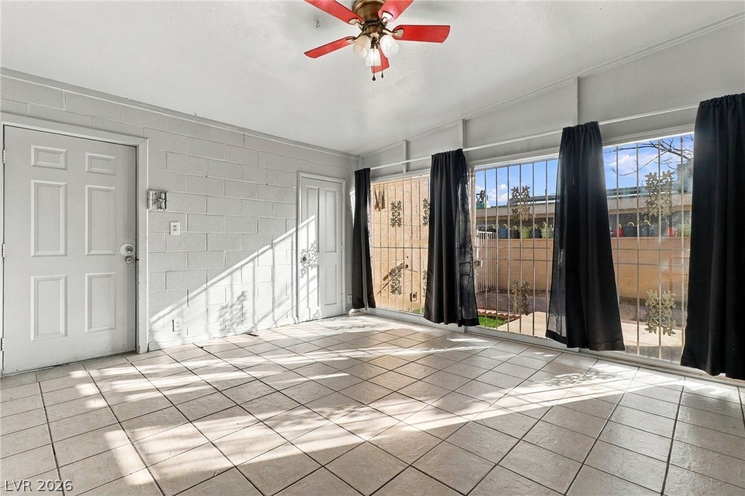 2521 Perliter Avenue, North Las Vegas, NV 89030 Tiled floors and large sliding doors frame this versatile, light-filled living space.