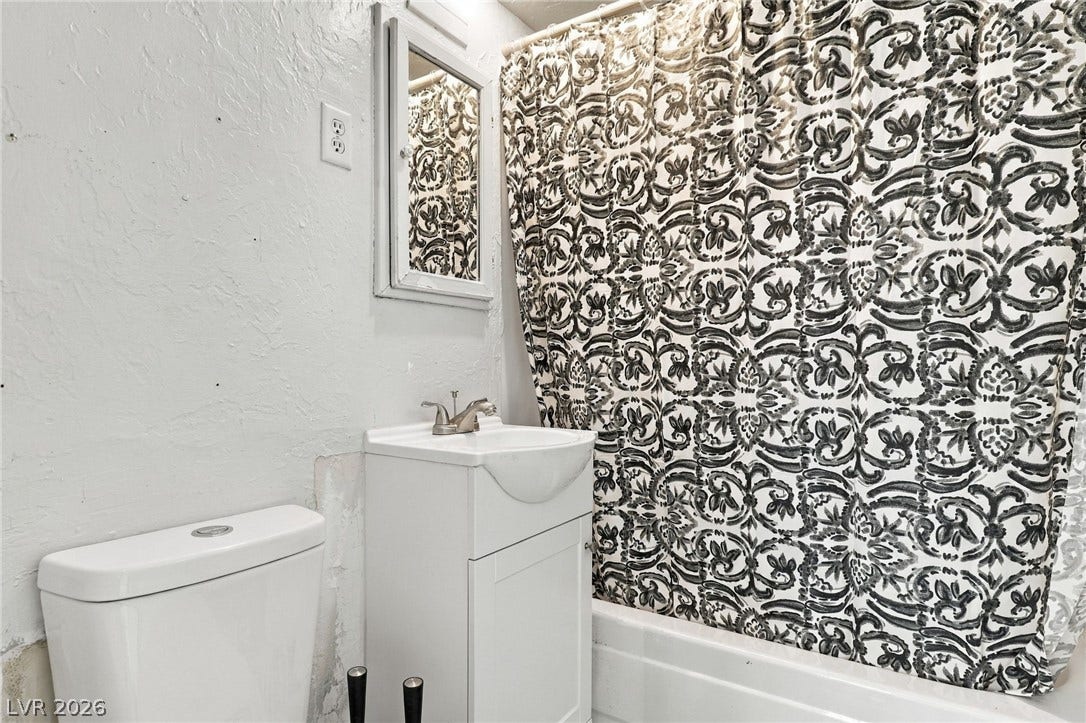 2521 Perliter Avenue, North Las Vegas, NV 89030 Textured plaster walls and a compact single vanity define this functional bathroom space.